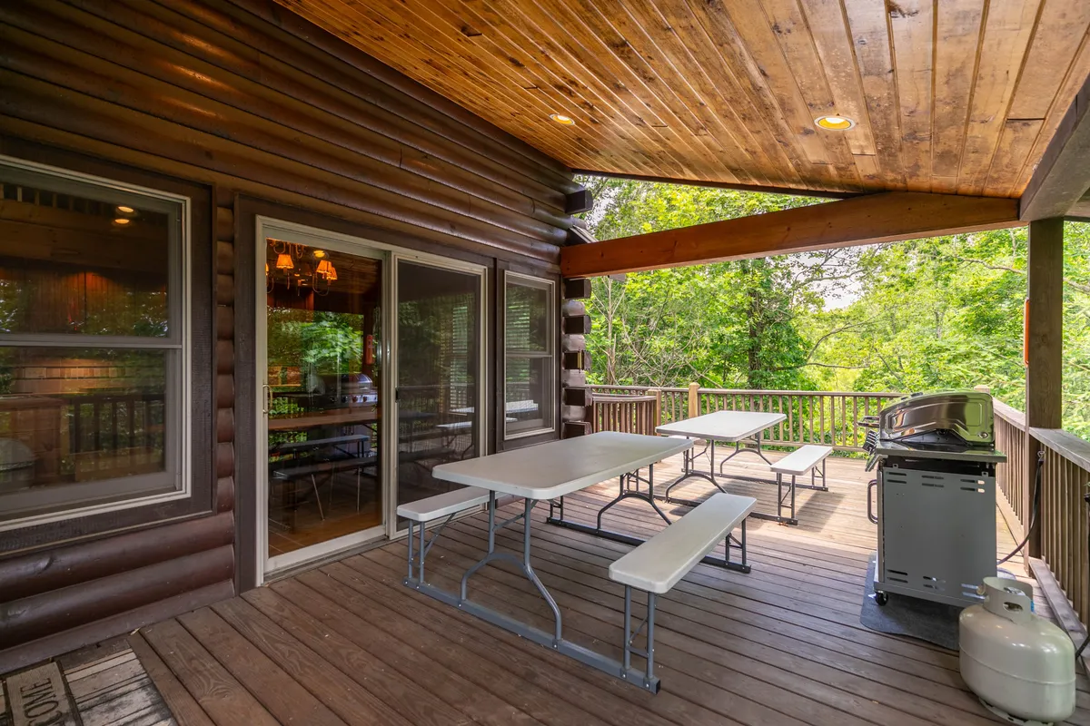 This image presents a relaxed wooden deck with outdoor seating, a grill, and views of surrounding greenery, suggesting a comfortable space for gathering before or after adventures.
