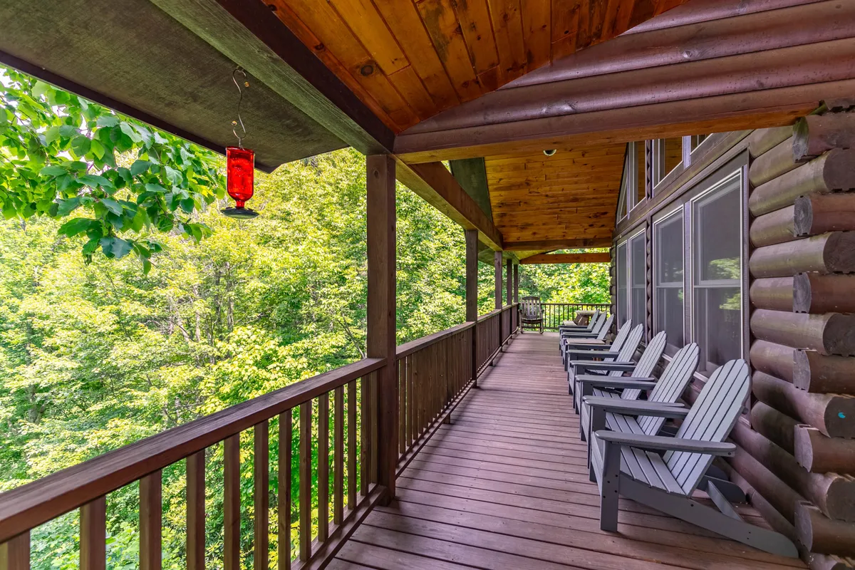 Featured here is a peaceful deck area with classic wooden rocking chairs, a hanging lantern, and lush greenery. The inviting setting is designed for sunset-watching, stargazing, and quiet relaxation in nature.